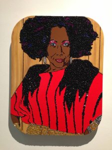 Installation view of part of Mickalene Thomas's depiction of her mother: "Ain’t I Woman, Sandra," 2009. Rhinestones, acrylic paint, and oil enamel on wood panel. DVD and framed monitor; rhinestones, acrylic paint, and enamel on wood.