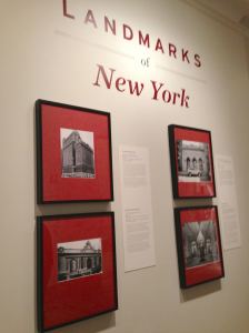 Installation view featuring photos of the Whitehall Building (17 Battery Place), Grand Central Terminal, the Free Public Baths (538 East 11th), and the interior of the Plaza Hotel